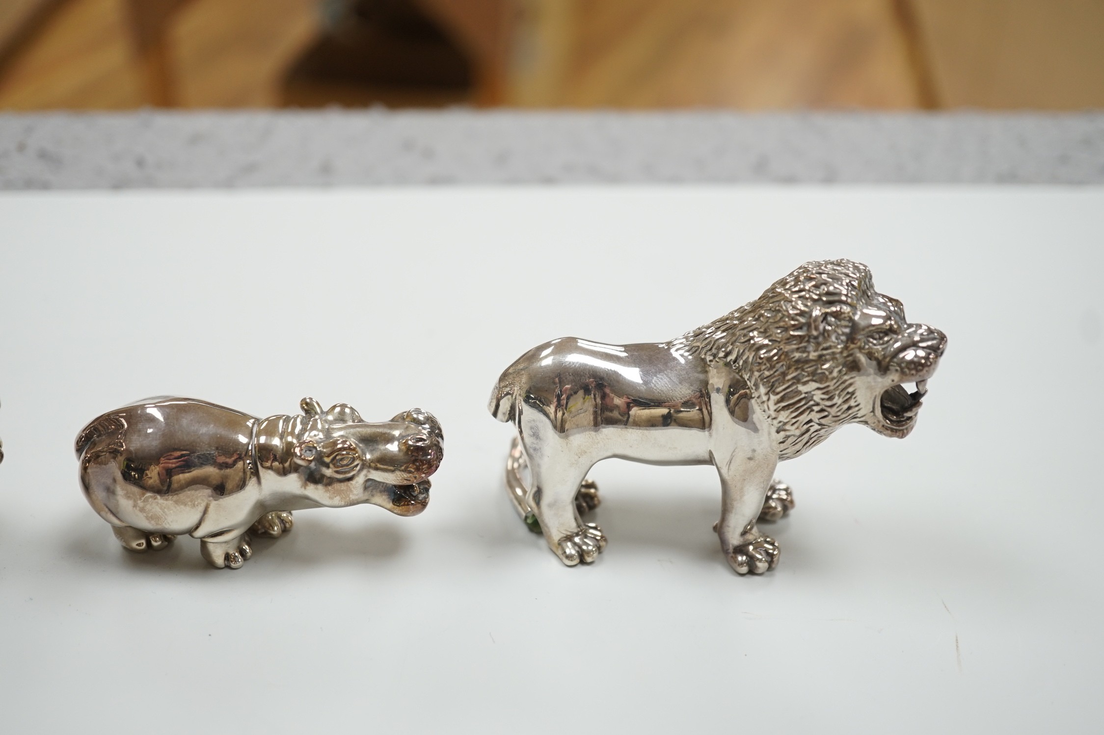 Four modern 925 overlaid miniature models of animals including two lions and a similar leopard napkin ring (one lion a.f.).